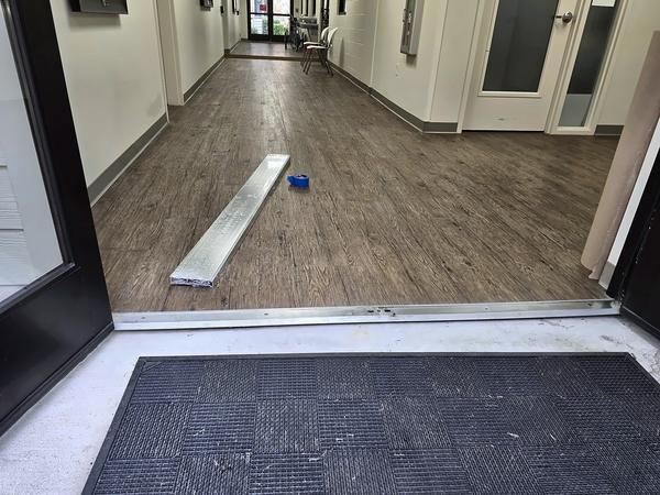 Entrance doorway with a gap below the old threshold between the concrete and the interior floor